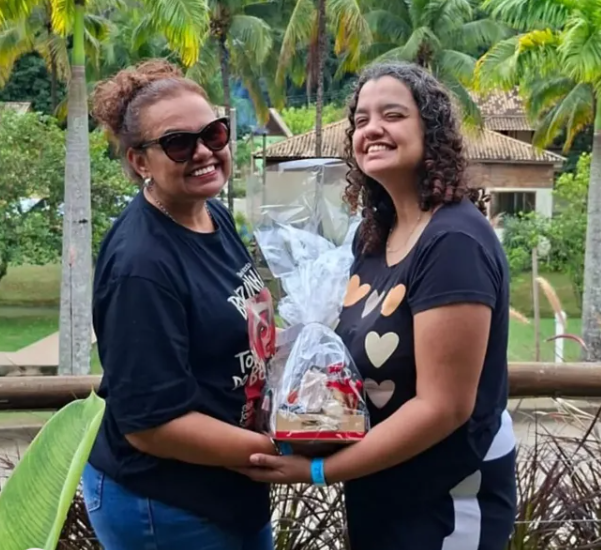 Bia e sua mãe sorrindo juntas com a cesta de aniversário